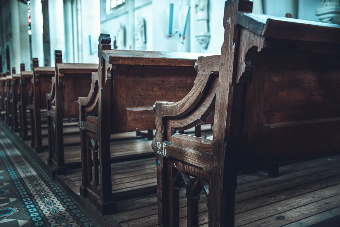 Rows of wooden pews in a sunlit sanctuary between services